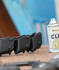 CLP Gun Cleaner Lubricant Preservative Spray with Synthetic Oil, 4 oz aerosol, next to firearm accessories on wooden surface.