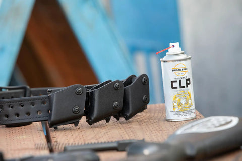 CLP Gun Cleaner Lubricant Preservative Spray with Synthetic Oil, 4 oz aerosol, next to firearm accessories on wooden surface.