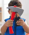 Child holding an axe and toy radio from Kids Firefighter Costume Props Set With Water Squirt Fire Extinguisher Toy For Role Play Realistic Fireman Gear With Interphone Megaphone Axe And Toy Radio Perfect For Pretend Play Parties Educational Safety Activities.