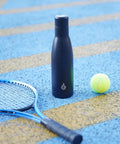 Boss Grade 17 Oz Insulated Thermal Water Bottle With Airtight Drip Proof Lid Double Wall Vacuum beside a tennis racquet and ball.