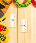 Two Pack Automatic Hidden Door Hinges With Spring Loaded Self Closing For Residential Use Concealed Crystal Clear Interior Hinges 45x35mm With Screws Sleek Modern Look For Doors And Windows shown with tools on wooden background