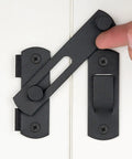 Black latch screw-mounted on a white door with hand demonstrating functionality