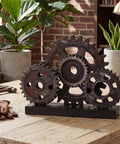 Novabright Vintage Copper Steampunk Gear Train Figurine For Desk Decor, rustic wooden cog wheel on a table with plants.