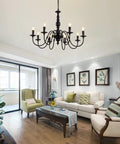 Metal 8 Light Candle Style French Country Chandelier Black Farmhouse Pendant Lighting For Kitchen Island, Dining Room, Bedroom, And Living Room, 30 Inch Diameter, Modern Rustic Vibe hanging in a living room.