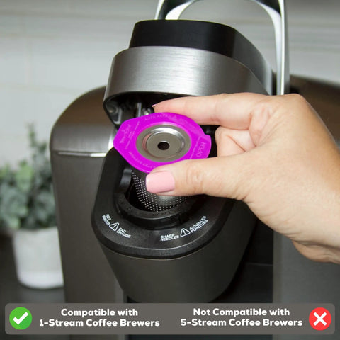 Hand placing stainless steel reusable K Cup coffee pod with built-in filter into Keurig single serve brewer