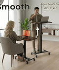 Man and woman using Rollin Laptop Standing Desk With Adjustable Height On Wheels Mobile T Base With Locking Casters Sit Stand Workstation In Walnut Finish
