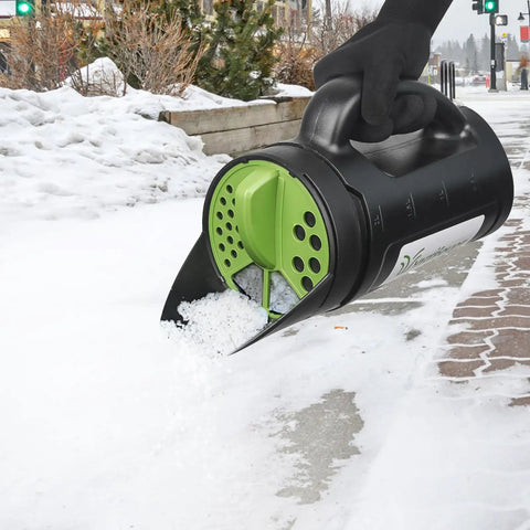 Handheld Spreader For Lawn And Garden With 80 Oz Capacity Adjustable Opening For Seed Fertilizer Salt Ice Melt in use on snow