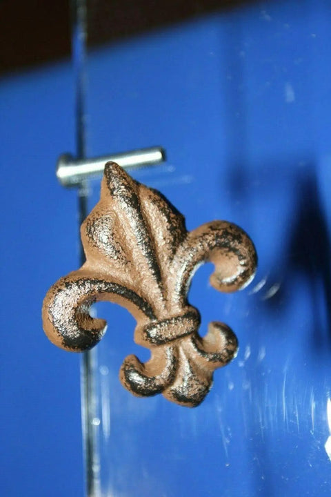 Old School Vintage Fleur De Lis Cabinet Knobs Set in cast iron on a blue background