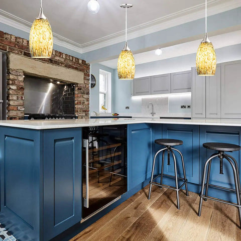 Kitchen island with three light pendant set featuring hand blown yellow glass shades, chrome canopy, modern design.