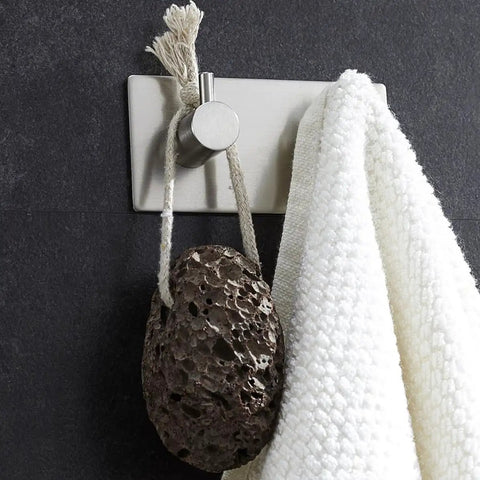 Heavy Duty Stainless Steel Wall Mounted Hooks Featuring Super Strong Self Adhesive Tape For Bathroom Towels Coats And Home Organization No Drill Hassle Rust Proof Daily Setup with white towel and lava stone.