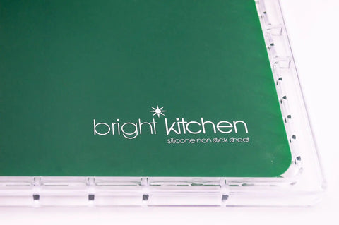 Heavy Duty Silicone Non Stick Dehydrator Mats For 6 Tray Ovens And Countertops Tough No Fuss Kitchen Baking Sheets For Fruit Roll Ups Crackers And Jerky Legit Teflon Free Flat Dry Trays with bright kitchen logo on green surface.