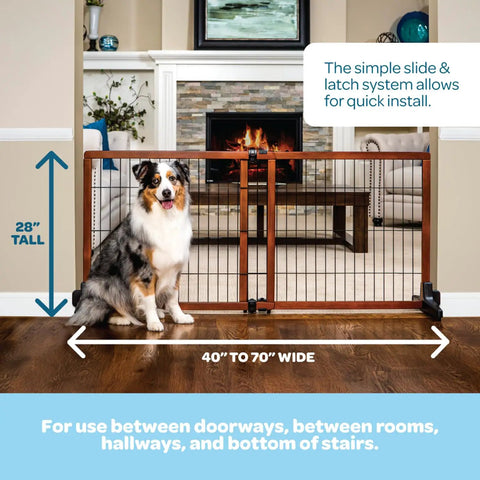 Extra Tall 28 Inch Freestanding Dog Gate, Super Wide 40 To 70 Inch Adjustable, in front of fireplace with a dog beside it.