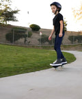 Rider using RipStik Ripster Caster Board For Narrow Stance Riders 9 Inch Blue With 360 Degree Trucks on a park path.