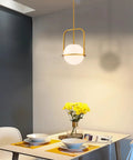 Slick Brass Pendant Light For Kitchen Island With Adjustable Height And Soft Frosted Glass Globe Ceiling Lamp For Dining Room Entryway Bedroom Modern Hanging Fixture Top Shelf Home Decor above dining table with yellow flowers.