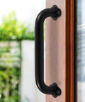 Matte Black 12 Inch Wall Mount Stair Handrail 1.3 Inch Metal Pipe Grab Bar on wooden surface for outdoor use