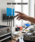 Four Slot Magnetic Pry Bar Organizer With Mounting Holes For Garage Or Shop on wall holding blue-handled pry bars.
