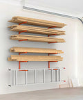 Wall-mounted lumber storage rack in garage, steel with orange accents, holding wood planks and ladder, space-saving solution.