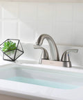 Two Handle Deck Mounted Bathroom Sink Faucet With Brushed Nickel Finish in modern bathroom setting, near sink with overflow