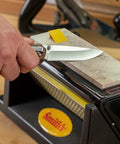 Person sharpening a knife on Diamond Tri-Hone Bench Stone Set 8 Inch With Coarse Fine And Natural Arkansas Stones Three Way Honing System.