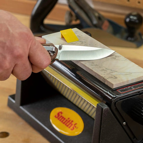 Person sharpening a knife on Diamond Tri-Hone Bench Stone Set 8 Inch With Coarse Fine And Natural Arkansas Stones Three Way Honing System.