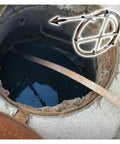 Heavy Duty Manganese Steel Drain Snake With Tough Impact Head and Storage Rack used in a clogged drain opening for effective clearing.
