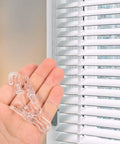 Rock Solid 12 Piece Blind Wand Replacement Hooks Built With Heavy Duty Alloy For Smooth Tilt Action And Fast Window Treatment Repairs Around Your Place, clear clips held in a hand.