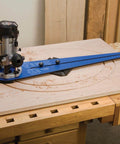 No Fuss Ellipse Router Circle Cutting Jig For Woodworking shown in use on a wooden panel, attached to a plunge router for precise cuts.