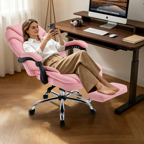 Woman relaxing in a Comfy Reclining Office Chair With Footrest For Women, Pink, at a gaming desk, showcasing the footrest feature.