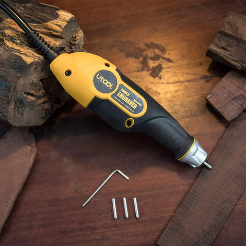 Electric engraver tool with attached engraving bit and wooden blocks around