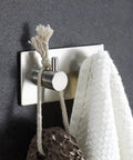 Heavy Duty Stainless Steel Wall Mounted Hooks Featuring Super Strong Self Adhesive Tape For Bathroom Towels Coats And Home Organization No Drill Hassle Rust Proof Daily Setup with white towel.
