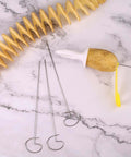 Manual Tornado Potato Spiral Cutter with potato on white plunger; yellow handle and metal skewers on marble surface