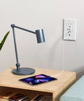 Haul This Smooth Usb Wall Outlet With Two Type C And One Type A Ports For Reliable Six Amp Fast Charging To Keep Every Gadget Pumped Full Of Juice No Fuss Ever Just Install And Go In Classic White, mounted next to a modern desk lamp and tablet.