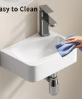 HAOCHRYSYPH Wall-Mounted Bathroom Sink, Ceramic, Milk White, 14x10 in. Being cleaned with a cloth for easy maintenance.