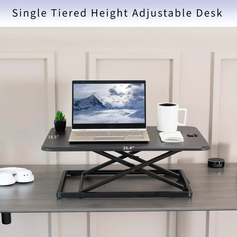Ultra Slim Single Top Standing Desk Riser Height Adjustable Sit Stand Converter, black steel with laptop and cup on top.
