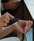 Person using a screwdriver from the 152 Piece Basic Household Hand Tool Set With Toolbox Storage Case All Purpose Home Tool Kit Includes Essential Tools For Office And College Repairs Purple on a table corner.