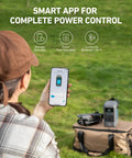 Person controlling 192Wh Portable Power Station With LiFePO4 Battery, 200W Solar Generator using smartphone app outdoors.