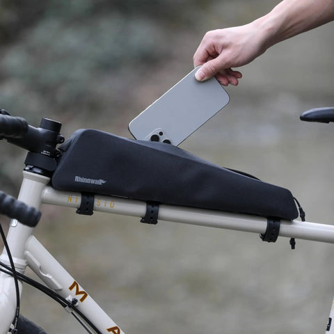 Extra Long 1.6L Top Tube Bag With Strap Mount on bike, black, sleek design, person placing phone inside zippered waterproof frame bag