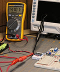 Two Pack Multimeter Test Lead Set With Wire Piercing Probes And Insulated Back Probes For Diagnostic Electrical Testing, shown in use on a circuit board
