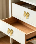 Six Piece Zinc Alloy Bow Drawer Knobs With Vintage Plating And Smooth Curved Handles For Dressers And Vanity Furniture Upgrades That Bring Main Character Energy To Your Space, gold pulls on white drawer.
