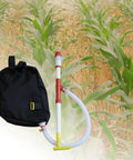 Backpack Sprayer And Manure Distributor For Vegetables With PVC Tube Handy Workhorse for farm or garden, shown with crop background