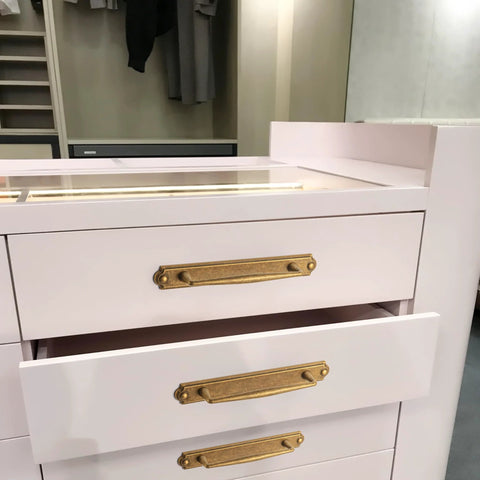 Antique Brass Zinc Alloy Cabinet Handle With Backplate installed on white drawers in a bedroom setting, 5 Inch Center to Center.