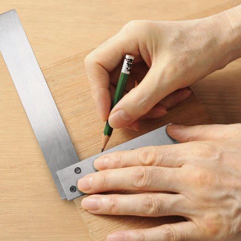 Suwimut machinist square set, steel L-shaped 90-degree ruler in use to mark wood; hands visible.