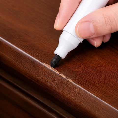 Deliver A No Sweat Slick Finish With This Elite Furniture Fix Kit Featuring Three Premium Wood Touch Up Markers In Rich Black Cherry Walnut Tones To Knock Out Stubborn Scratches And Freshen Up Floors Or Cabinets Fast. A hand using a black touch up marker on furniture.