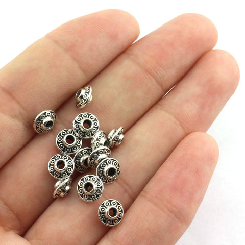 Hand holding 100 Pcs 6 mm Antique Silver Flying Saucer Spacer Beads European Style Metal Beads For Jewelry Making, Bracelets And Necklaces, Dope For Pandora DIY Projects