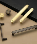 Four Pack Three Point Eight Inch Coffee Antique Brass Cabinet Pulls Handles in gold and black viewed from above on display surface.