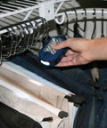Hand holding Magnetic LED Work Light Six Pack With 27 LED Lights And Swivel Hook, illuminating clothes in closet.