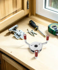 Pro Grade Hella Rugged Stainless Steel Smoke Transducer Removal Tool With Heavy Duty Grippers on a workbench with tools.