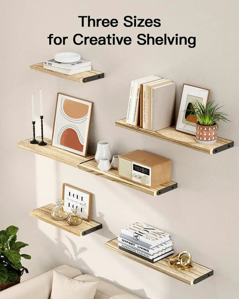 Solid Natural Paulownia Wood Floating Shelves Set Of Six displayed in three sizes with books, decor, and plants on a wall.