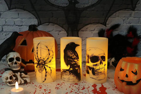 Halloween LED Flameless Candles 3 Pack With 6 Hour Timer Battery Operated 3 Inch Diameter By 6 Inch Height Spooky Decals Featuring Crow Raven Spider On Web And Skull Indoor Halloween Decor For A Chill Haunted Vibe displayed on a table with Halloween props
