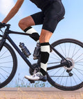 High Performance Unisex Athletic Compression Socks Featuring Graded Ankle Support Breathable Moisture Wicking Fabric Black White Piano Plate Grid Design on cyclist's legs.